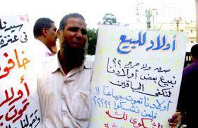 دام برس : دام برس | مواطن مصري يقف أمام مبنى مجلس الوزراء بوسط القاهرة ويعرض بناته للبيع